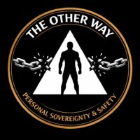 A circular emblem logo on a solid black background with a thick golden-bronze border. Along the top curve, bold white sans-serif text reads “THE OTHER WAY.” In the center, a large white equilateral triangle contains the silhouette of a fit person standing upright and facing forward. Broken silver chains burst outward from both sides of the triangle, with shattered links flying away from the center. Along the bottom curve, smaller gold sans-serif text reads “PERSONAL SOVEREIGNTY & SAFETY.” The design is symmetrical, high-contrast, and minimalist.